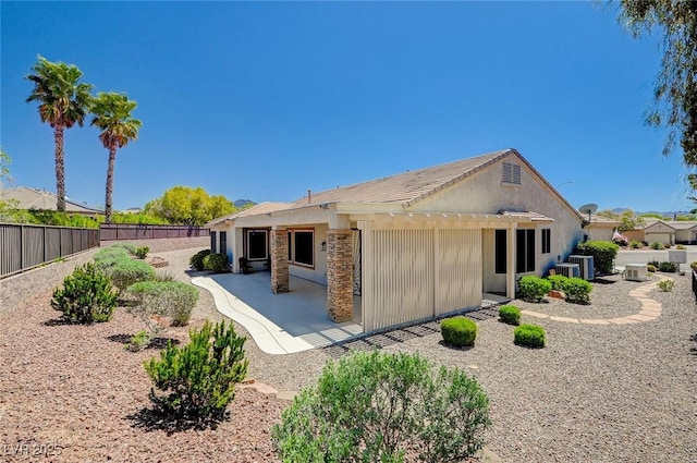 rear view of house featuring cooling unit and a patio