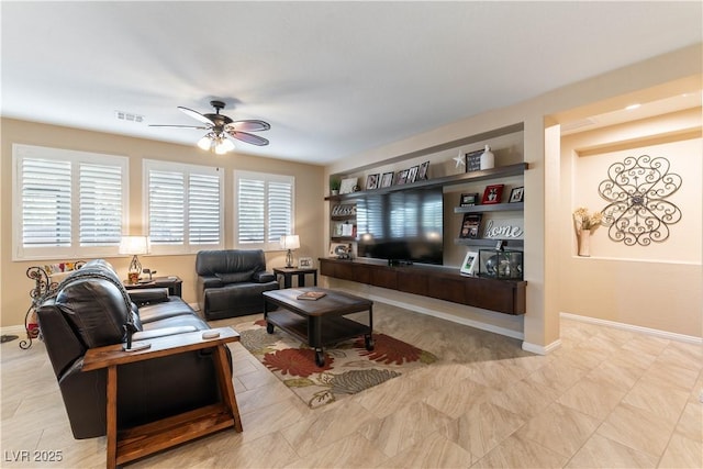 living room featuring built in features and ceiling fan