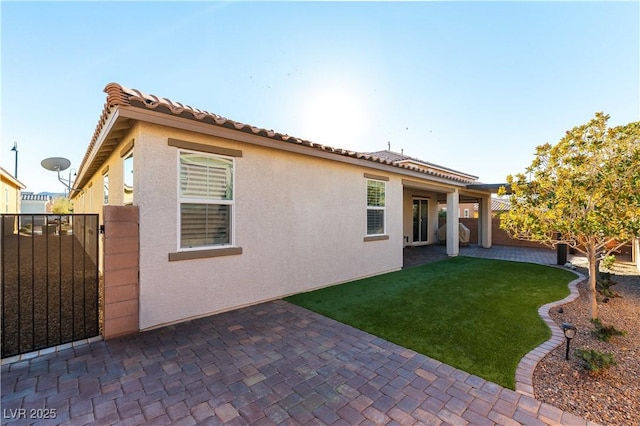 rear view of property with a yard and a patio