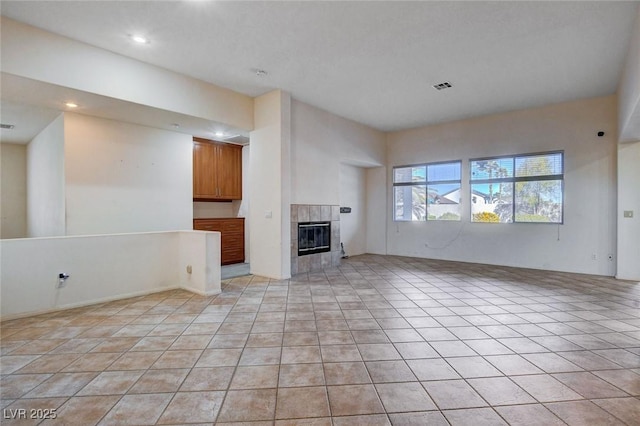 unfurnished living room with light tile patterned floors and a fireplace