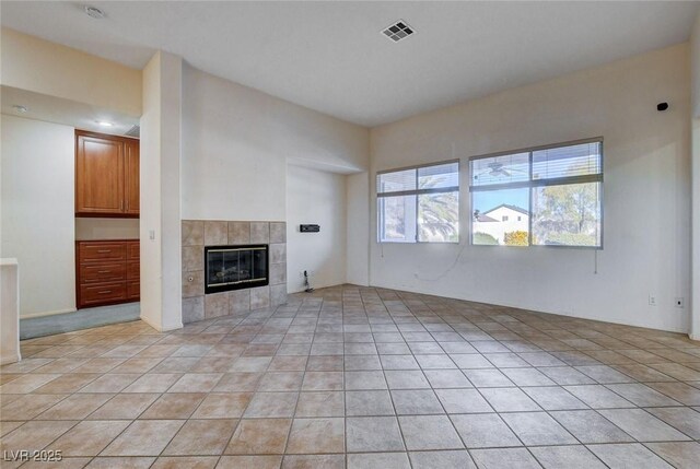 unfurnished living room featuring light tile patterned floors and a fireplace