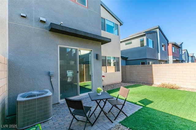 back of property featuring a patio area, a yard, and central AC