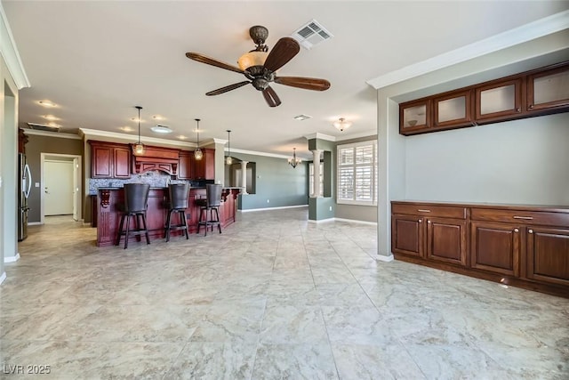 kitchen with a center island, stainless steel fridge, crown molding, and a breakfast bar