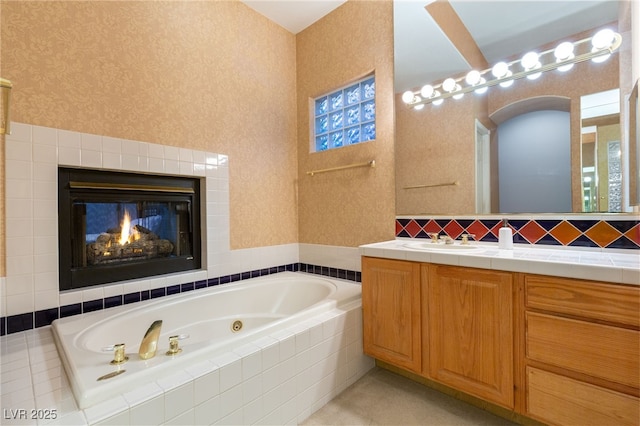 bathroom featuring vanity, a multi sided fireplace, and tiled tub