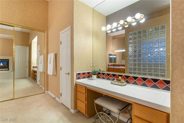 bathroom with a tiled fireplace and vanity