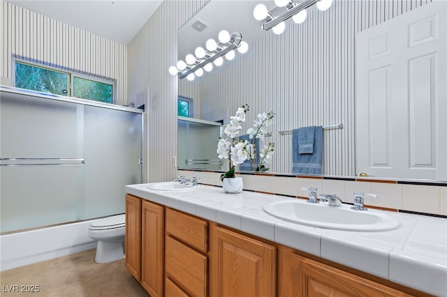 full bathroom featuring enclosed tub / shower combo, vanity, and toilet