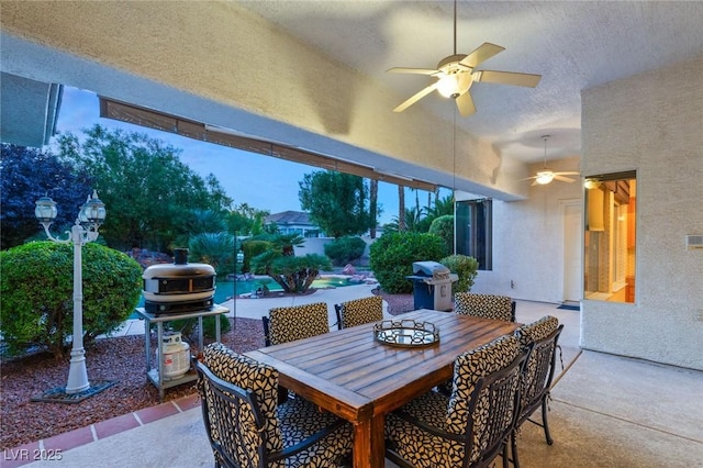 patio terrace at dusk featuring a grill and ceiling fan