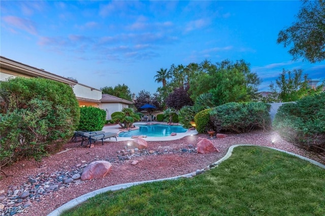 pool at dusk featuring a patio