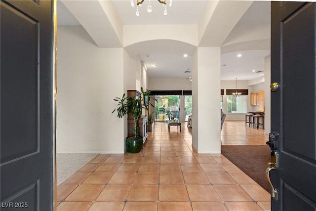 foyer entrance with light tile patterned floors and a notable chandelier