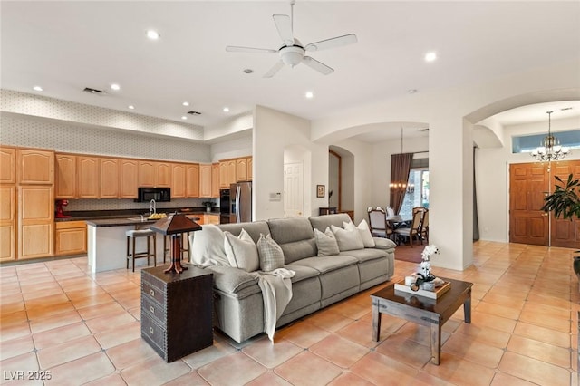 living room with ceiling fan with notable chandelier, sink, and light tile patterned floors