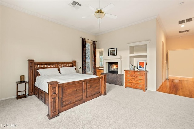 carpeted bedroom featuring ceiling fan and ornamental molding