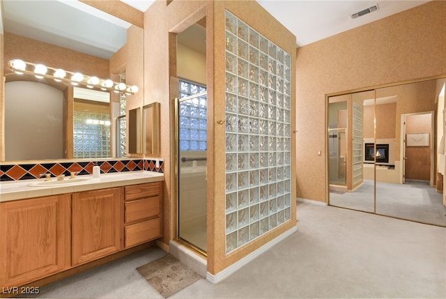 bathroom with a shower with door and vanity