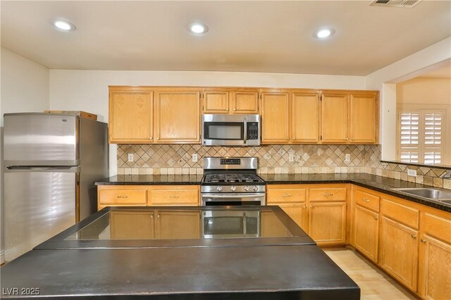 kitchen featuring decorative backsplash, sink, and appliances with stainless steel finishes