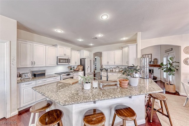 kitchen featuring stainless steel appliances, a breakfast bar, and white cabinets