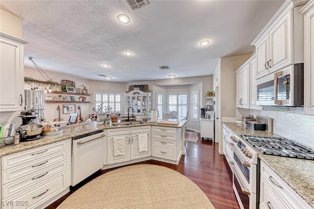 kitchen with white cabinetry, white appliances, and kitchen peninsula