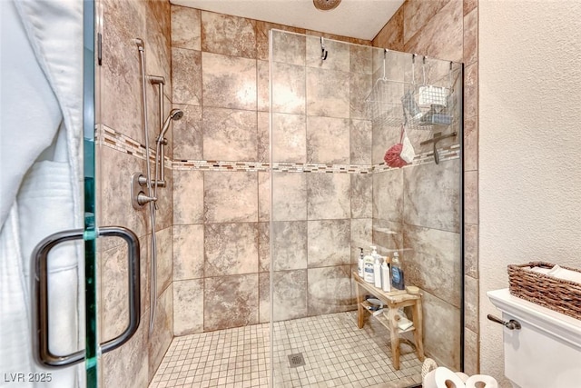 bathroom with toilet and a shower with door