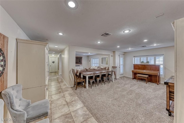 dining room with light carpet and a textured ceiling