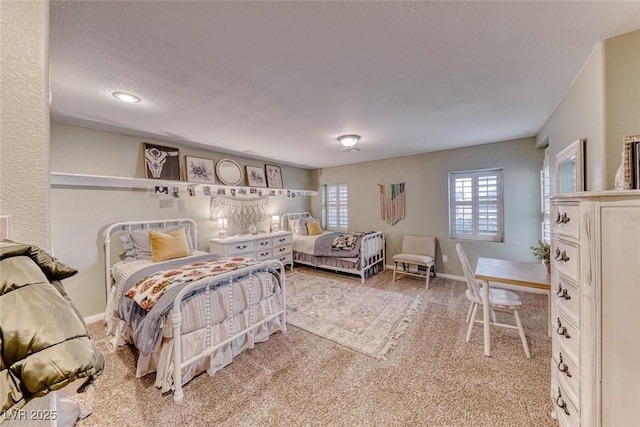 carpeted bedroom with multiple windows and a textured ceiling