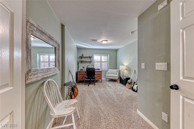 office area with carpet floors and a textured ceiling