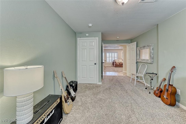 misc room with light colored carpet and a textured ceiling