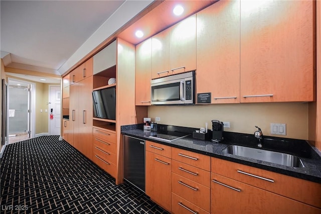 kitchen with sink, dishwasher, and dark stone counters