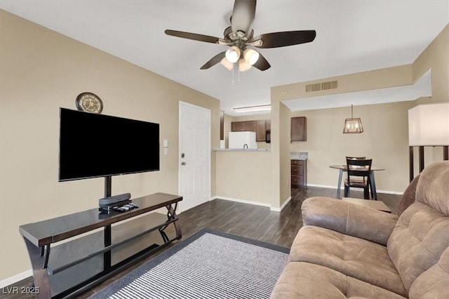 living room featuring ceiling fan and dark hardwood / wood-style floors