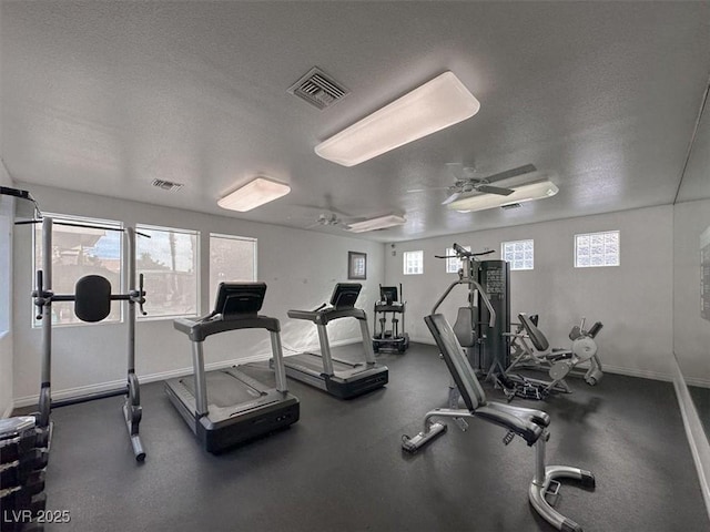 gym featuring a textured ceiling and ceiling fan