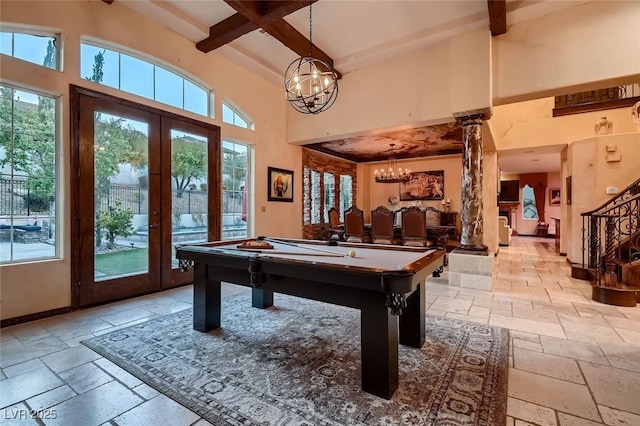 rec room featuring ornate columns, an inviting chandelier, a high ceiling, beam ceiling, and french doors