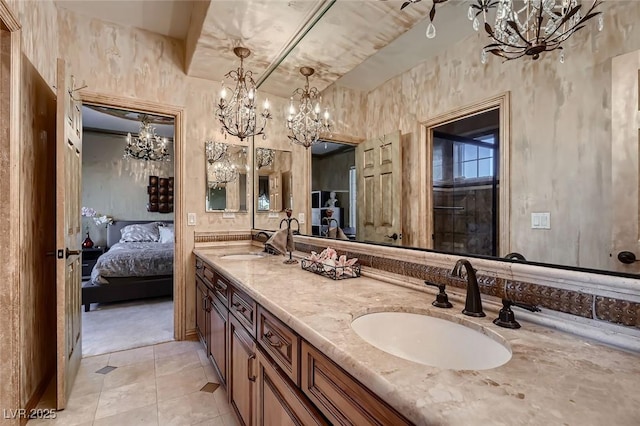 bathroom with an inviting chandelier, tile patterned floors, and vanity