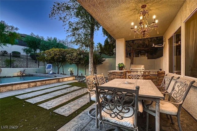 patio terrace at dusk with a pool, grilling area, and exterior kitchen