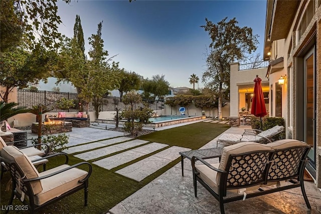 view of patio / terrace with a fenced in pool and an outdoor living space with a fire pit