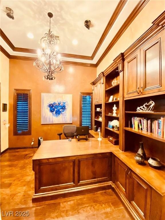 home office featuring a notable chandelier, hardwood / wood-style flooring, and ornamental molding