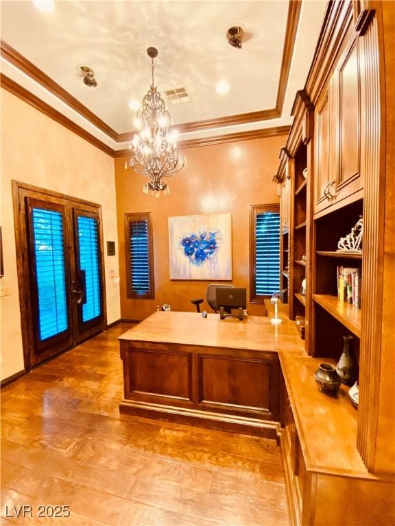 home office with crown molding, a chandelier, and french doors