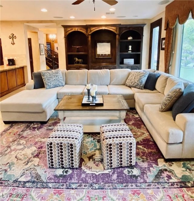 living room featuring ceiling fan and built in features