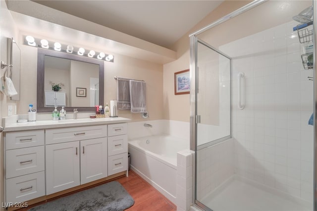 bathroom with hardwood / wood-style flooring, shower with separate bathtub, and vanity