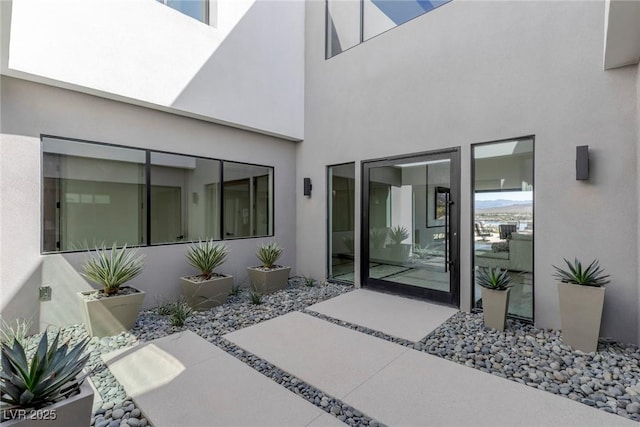 property entrance featuring a patio and stucco siding