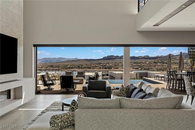 living room featuring light tile patterned floors, a high ceiling, and a mountain view