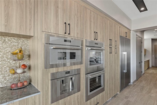 kitchen featuring appliances with stainless steel finishes, light brown cabinets, and modern cabinets