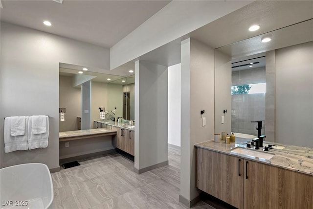 bathroom featuring a stall shower, recessed lighting, baseboards, and vanity