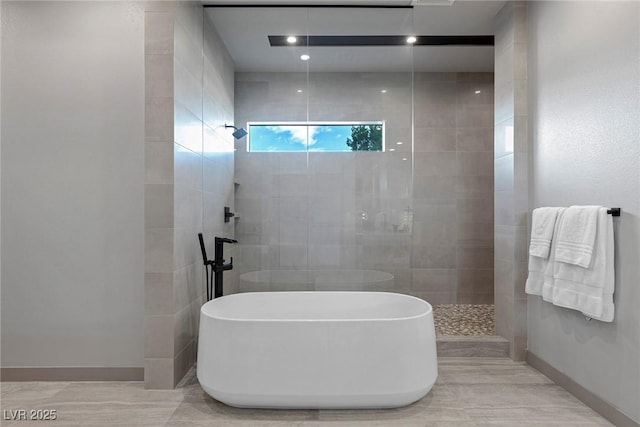 bathroom featuring a freestanding bath, baseboards, and a walk in shower