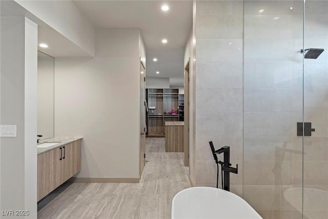 full bath featuring a soaking tub, a tile shower, vanity, and recessed lighting