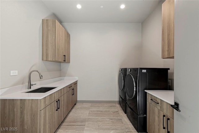 washroom with recessed lighting, independent washer and dryer, cabinet space, and a sink