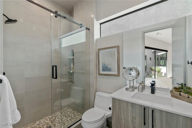 full bath with toilet, a shower stall, visible vents, and vanity