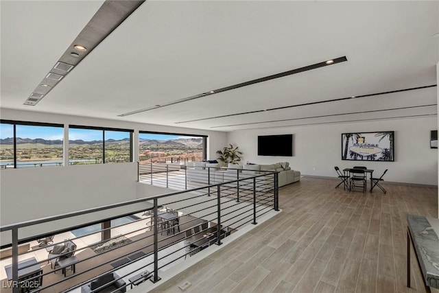 hall with a mountain view, an upstairs landing, and light wood-style floors