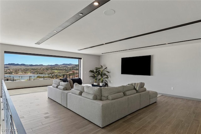 living room with a mountain view, baseboards, and wood finished floors