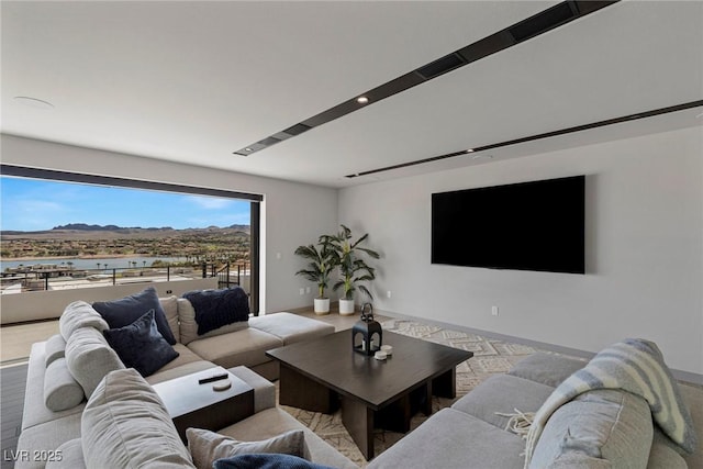 living area with light wood-type flooring, a mountain view, and baseboards