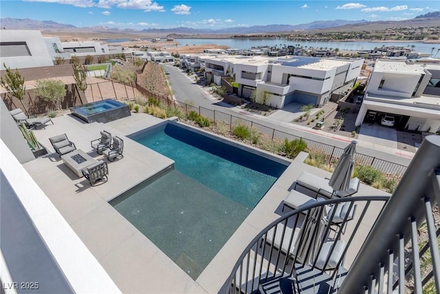 view of pool featuring a fenced in pool, a patio area, fence, and a water and mountain view