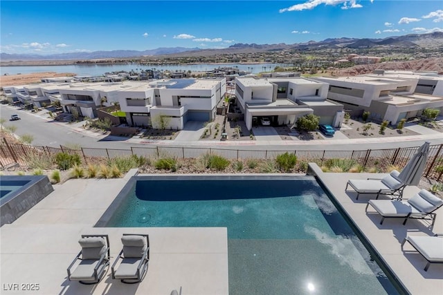 view of pool featuring a patio area, fence, a water and mountain view, and a fenced in pool