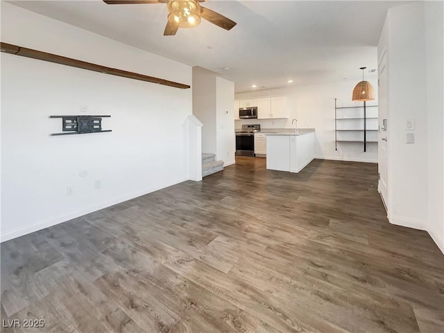 unfurnished living room with sink, ceiling fan, and dark hardwood / wood-style flooring