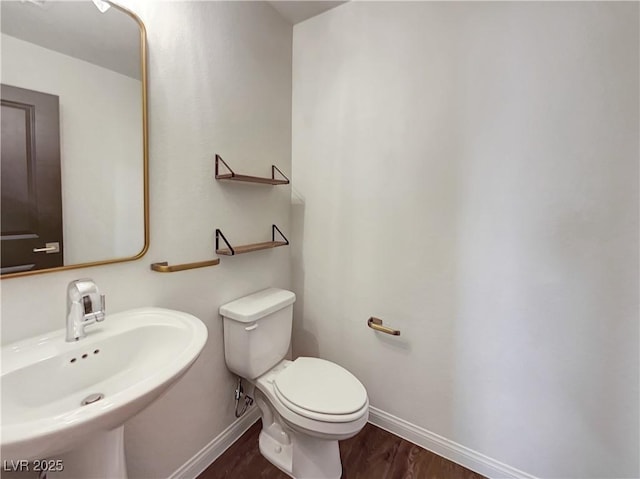 bathroom with sink, toilet, and wood-type flooring